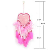 Pink heart-shaped dreamcatcher with feathers and measurements on a white background
