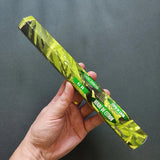 Hand holding a green incense stick with 'Herbe de Citron' text against a dark background