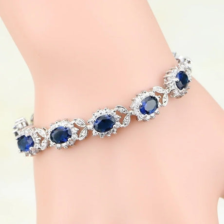 Bracelet with blue gemstones and silver accents on a wrist against a light background