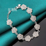 Silver floral bracelet on a teal fabric background