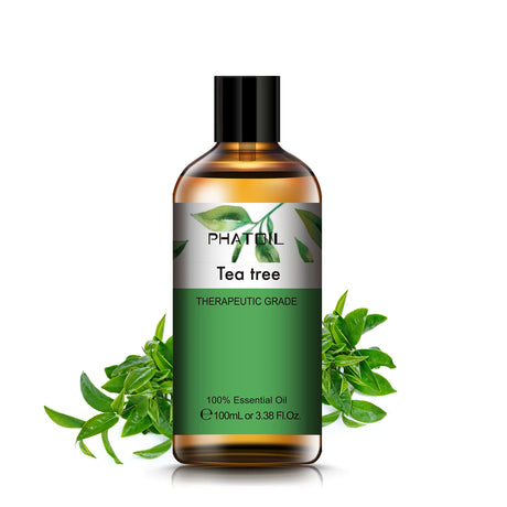 Bottle of Phatil Tea Tree essential oil with green leaves on a white background