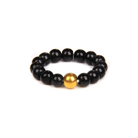 Black beaded bracelet with a gold focal bead on a white background