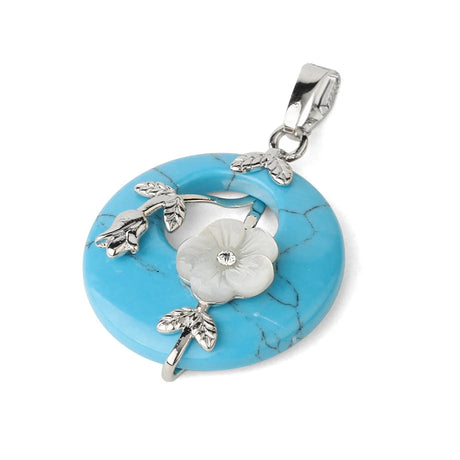 Turquoise pendant with silver floral design on a white background