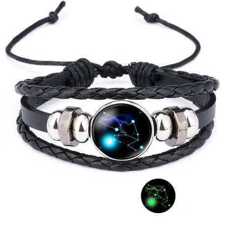 Black braided leather bracelet with silver accents and a glowing celestial design on a white background.