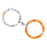 Two bracelets, one silver and one with orange beads, on a white background