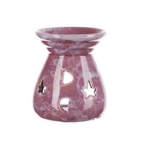 Pink marble-patterned oil burner with star and moon cutouts on a white background