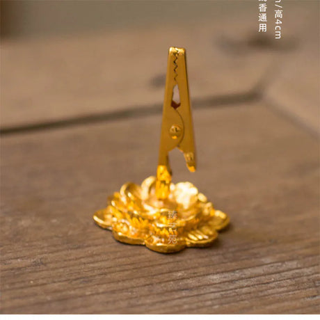 Gold-colored clip with coins on a wooden surface