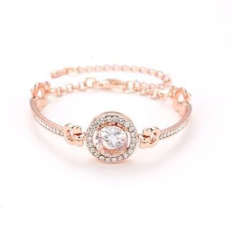 Rose gold bracelet with a central gemstone on a white background