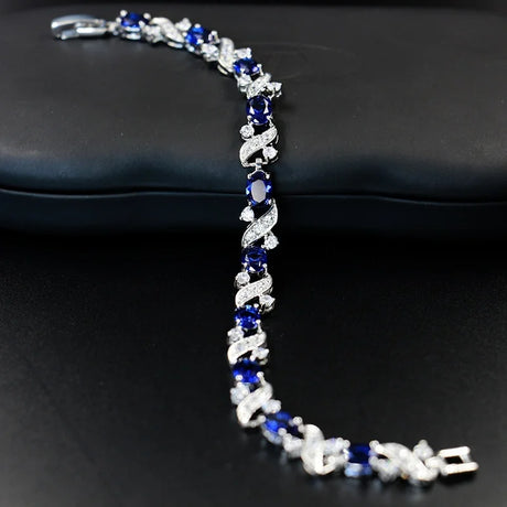 Silver bracelet with blue stones on a black surface