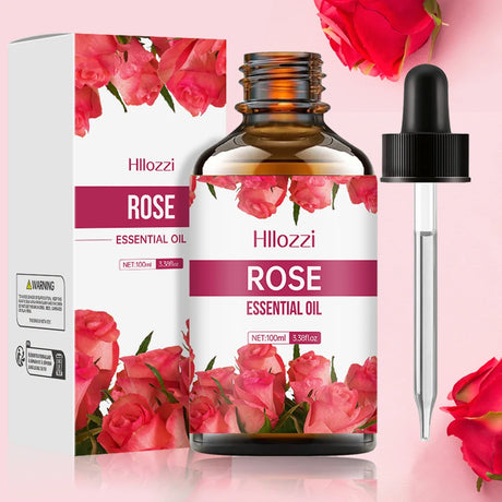 Hillozzi Rose Essential Oil bottle with dropper and packaging on a pink background with roses.
