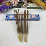 Incense sticks with a blue box on a white surface