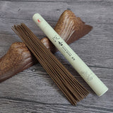 Incense sticks and a cylindrical incense box on a wooden surface