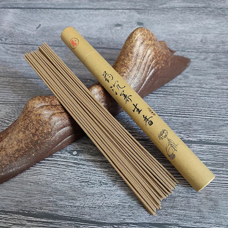 Incense sticks and their cylindrical packaging on a wooden surface