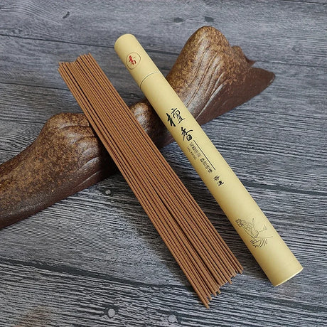 Incense sticks and their cylindrical holder on a wooden surface