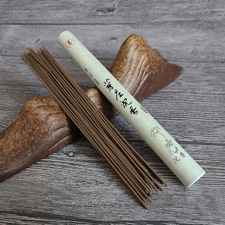 Incense sticks with a cylindrical container on a wooden surface