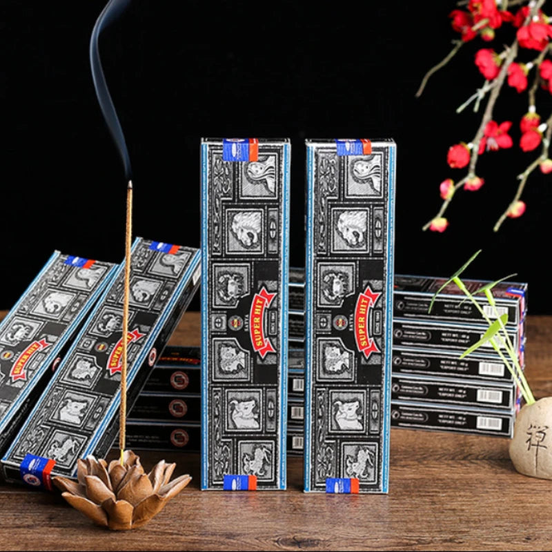 Incense sticks with decorative packaging on a wooden surface, with a dark background and floral elements.