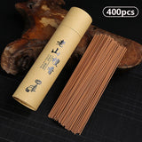 Kraft paper tube with incense sticks on a dark surface