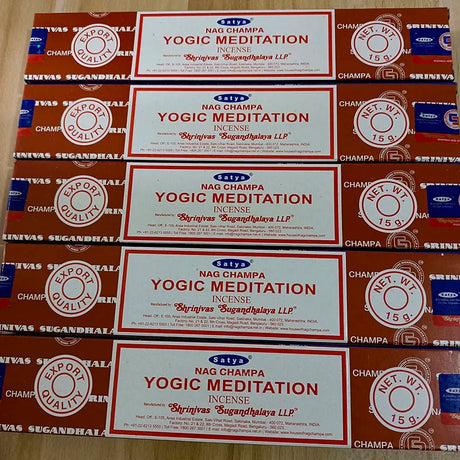 Multiple boxes of Satya Nag Champa Yogic Meditation incense on a wooden surface