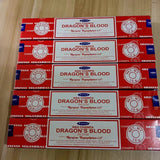 Multiple boxes of Nag Champa Dragon's Blood incense on a wooden surface