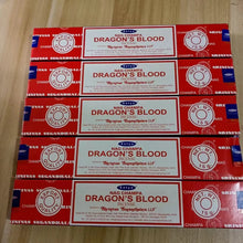Multiple boxes of Nag Champa Dragon's Blood incense on a wooden surface