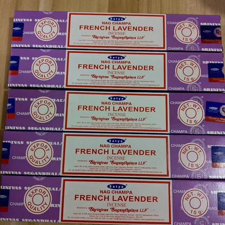 Multiple boxes of Nag Champa French Lavender incense on a wooden surface