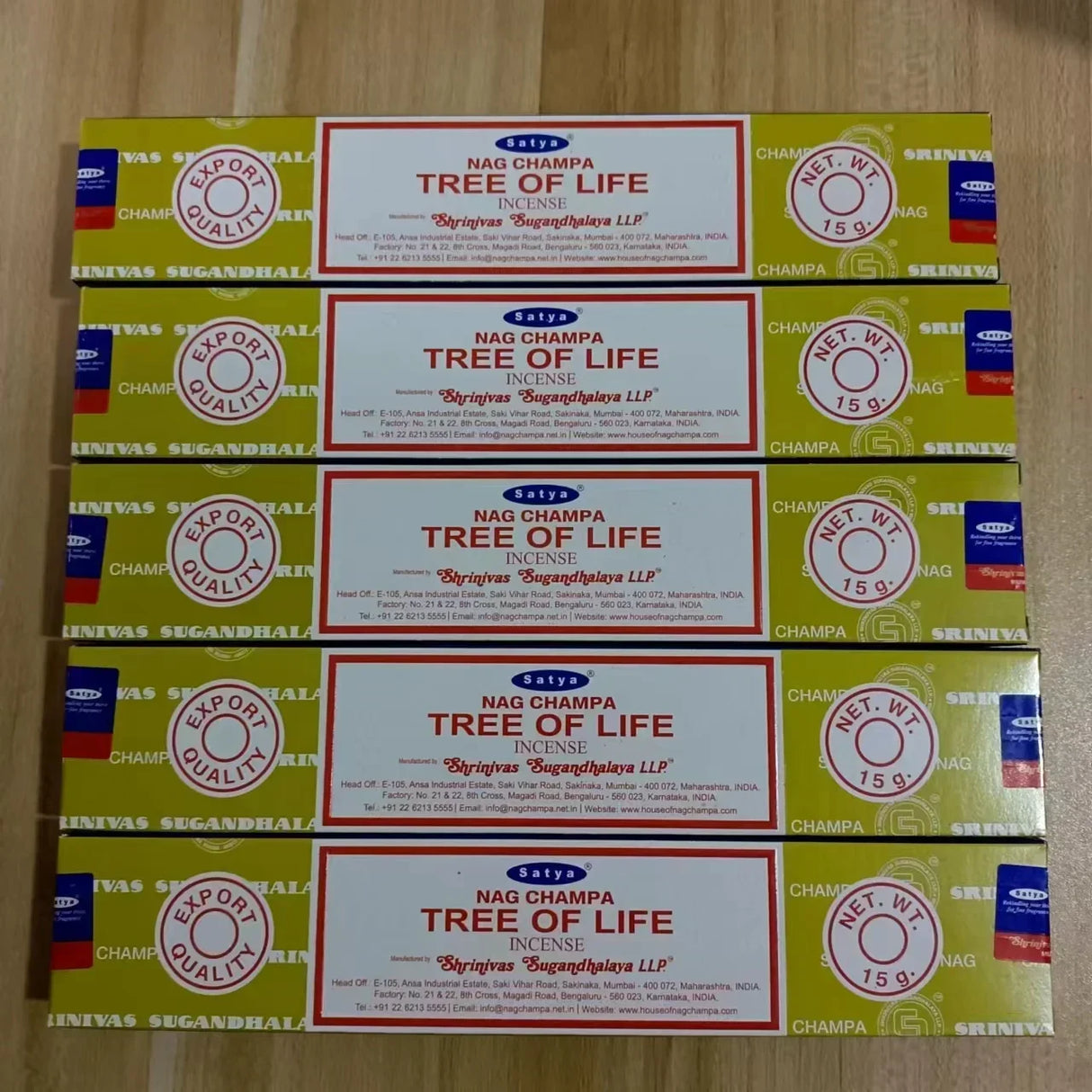 Multiple boxes of Nag Champa Tree of Life incense on a wooden surface