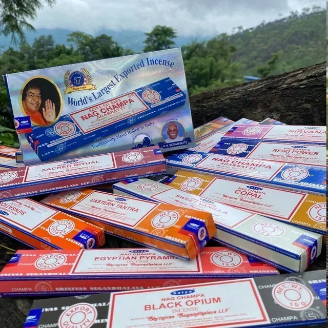 Collection of Nag Champa incense boxes with a scenic background