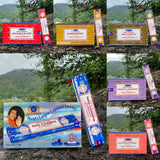 Collection of Nag Champa incense boxes with mountainous background