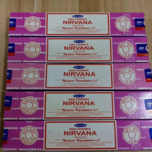 Multiple boxes of Nirvana Incense with purple and red packaging on a wooden surface.
