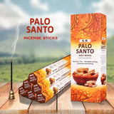 Palo Santo incense sticks with packaging on a wooden surface and blurred natural background