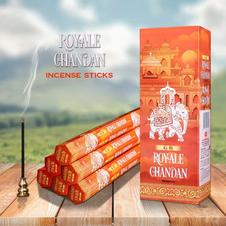 ROYALE GHANDAN incense sticks with packaging on a wooden surface and scenic background