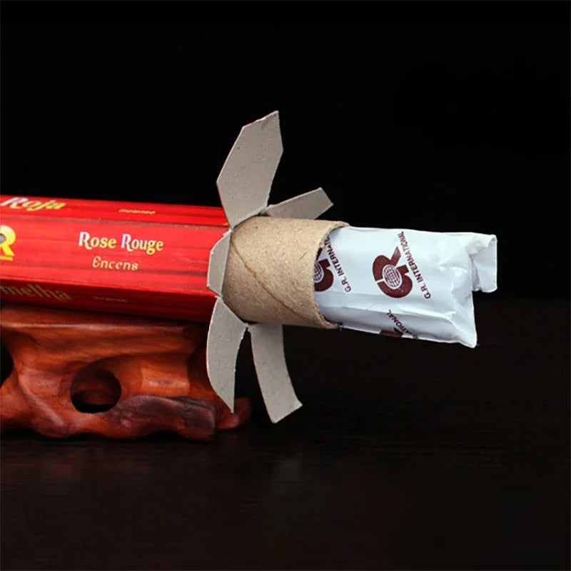 Red incense stick with a white label on a dark background