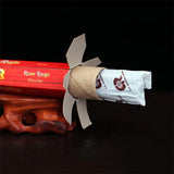 Red incense stick with a white label on a dark background