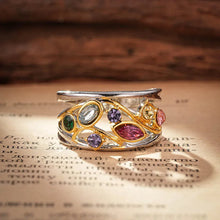Decorative ring with colorful gemstones on a textured surface