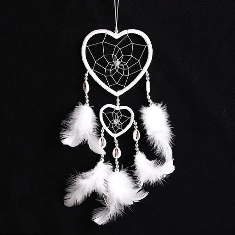 Heart-shaped dreamcatcher with white feathers on a black background