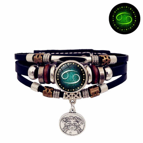 Multistrand bracelet with zodiac charm and green glowing feature on a white background