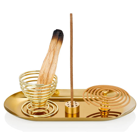 Gold incense burner with a single incense stick on a white background