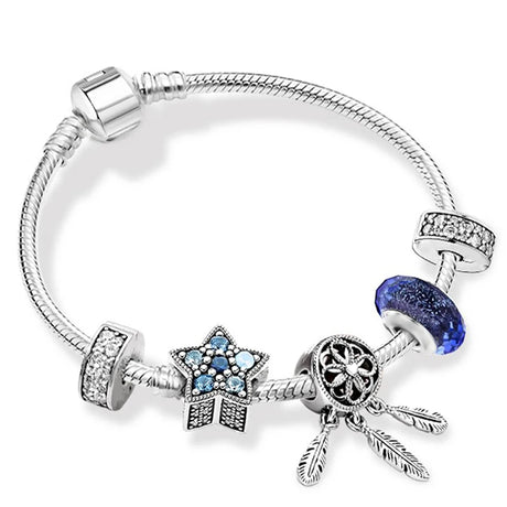 Silver bracelet with various charms on a white background
