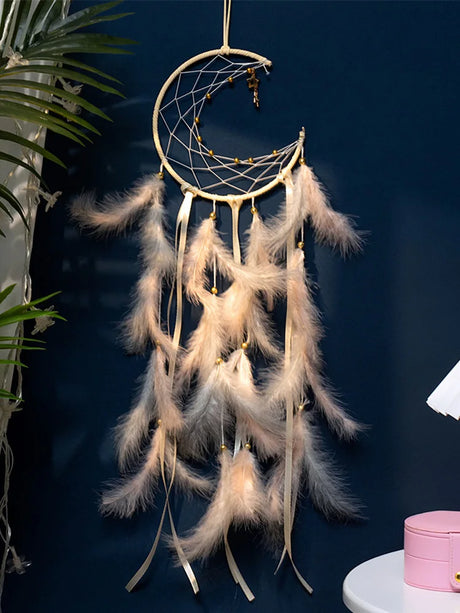 Dreamcatcher with feathers against a dark blue wall