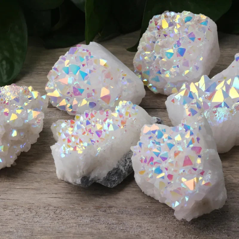 Iridescent crystal-like objects on a wooden surface with green leaves in the background