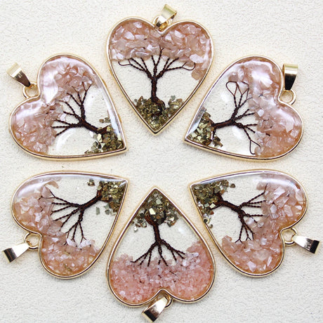 Heart-shaped pendants with tree designs on a light background