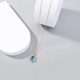 Gold necklace with a blue gemstone pendant on a light gray background