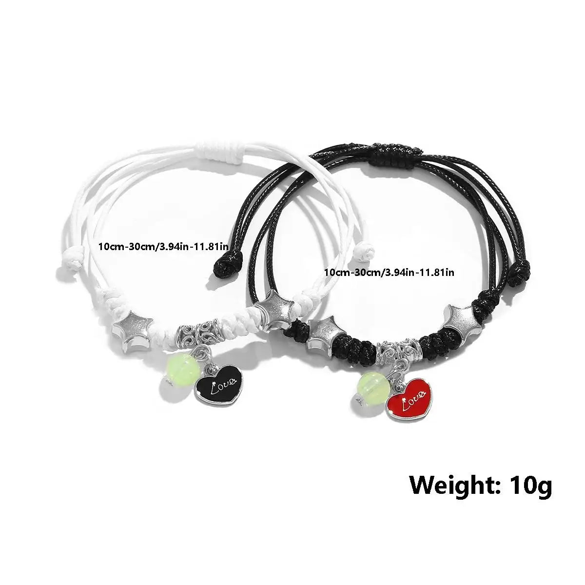 Two black and white bracelets with heart-shaped charms on a white background