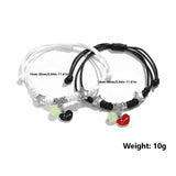 Two black and white bracelets with heart-shaped charms on a white background