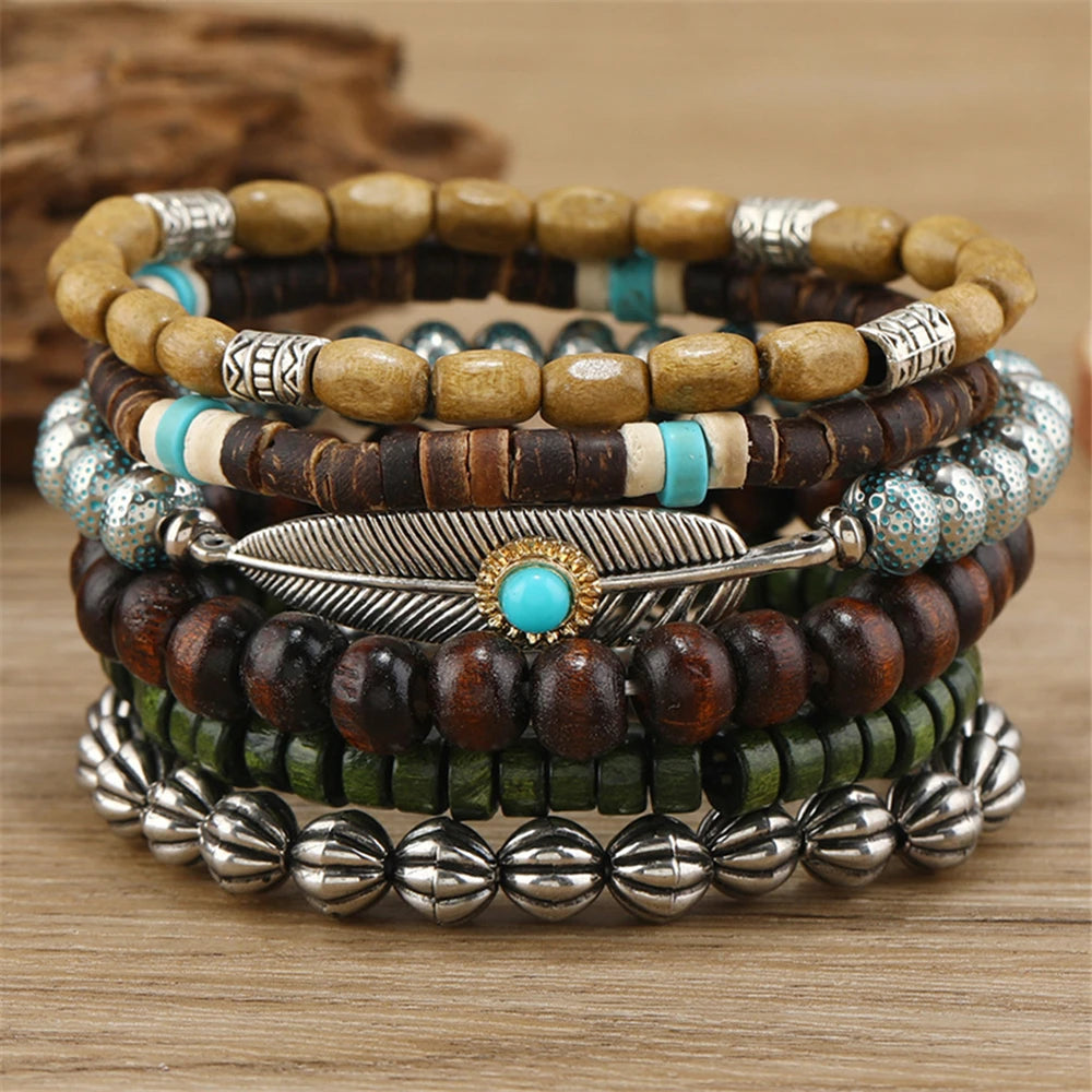 Stack of beaded bracelets with metal accents on a wooden surface