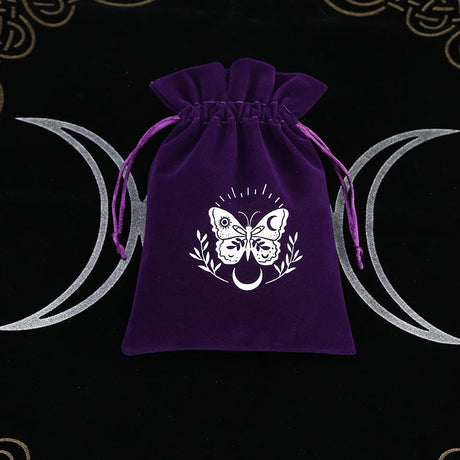 Purple drawstring bag with a white butterfly design on a black background with wiccan symbols.