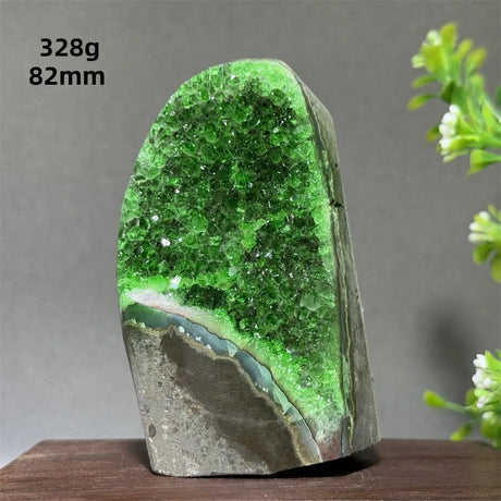 Green crystal rock on a wooden surface with a gray background