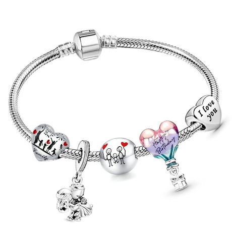 Silver bracelet with various charms on a white background