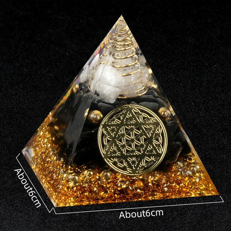 Pyramid-shaped object with gold and black design on a black background