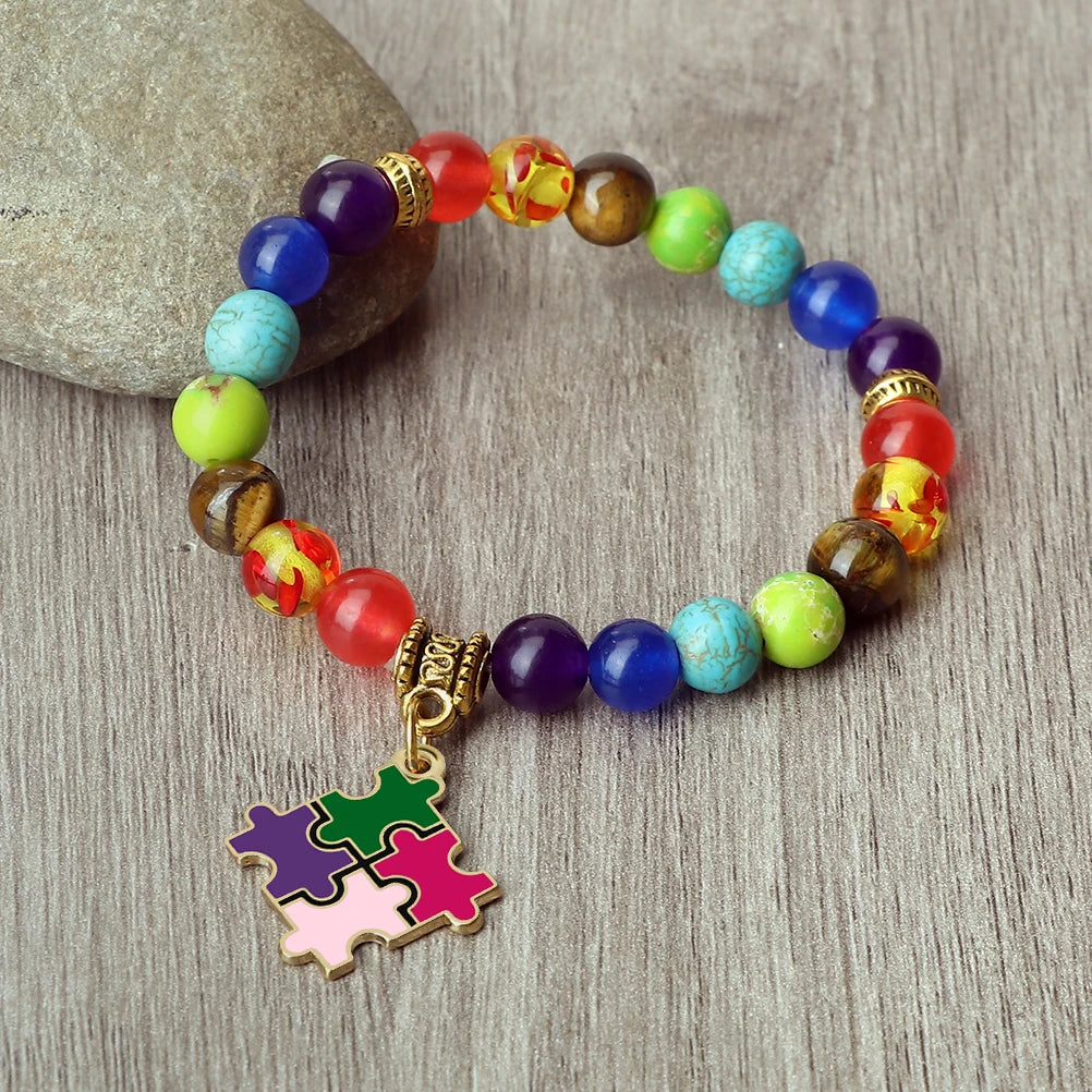 Colorful beaded bracelet with a puzzle piece charm on a wooden surface